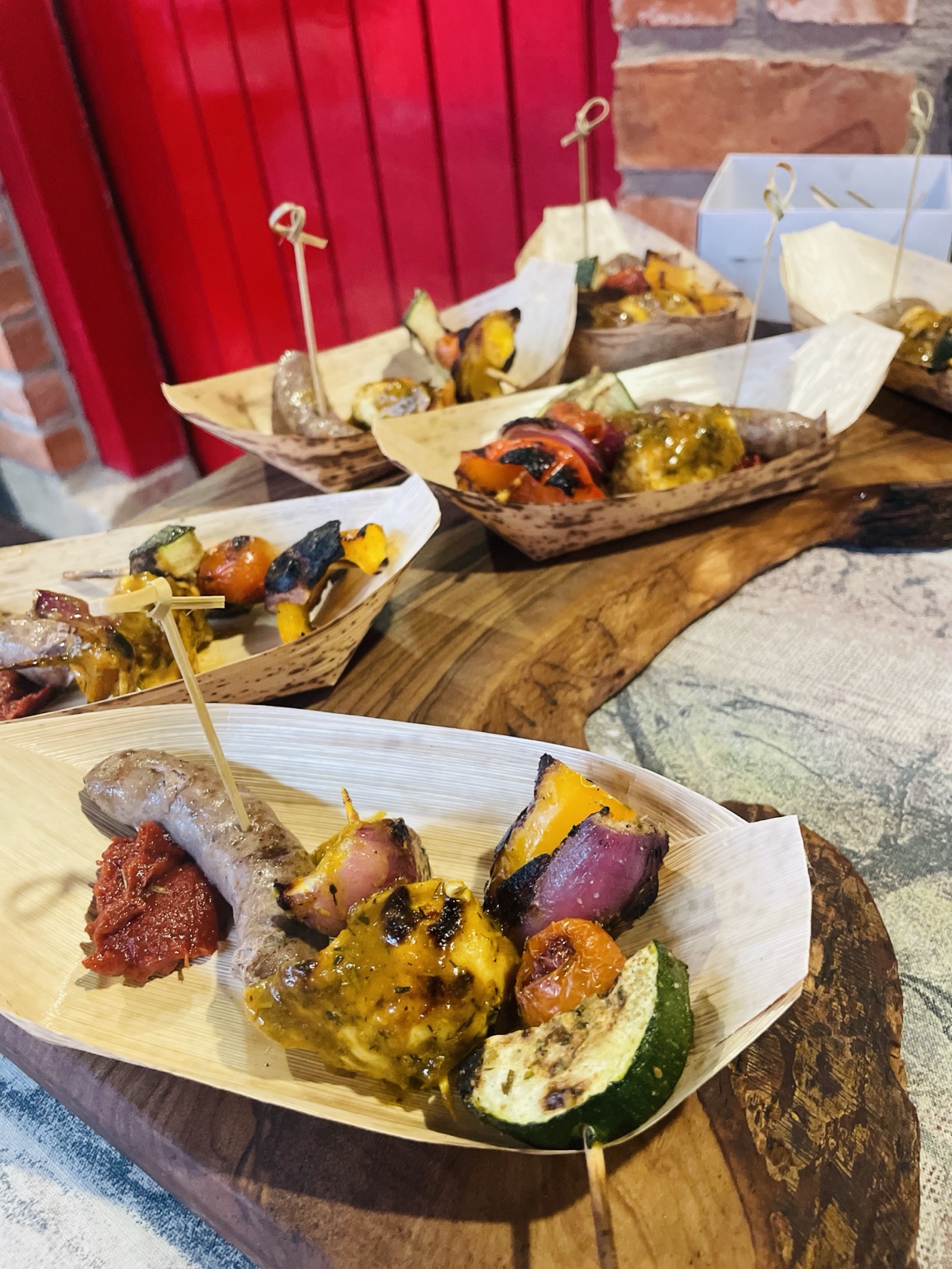 Braai skewers, sausage and charred vegetables served in wooden boats