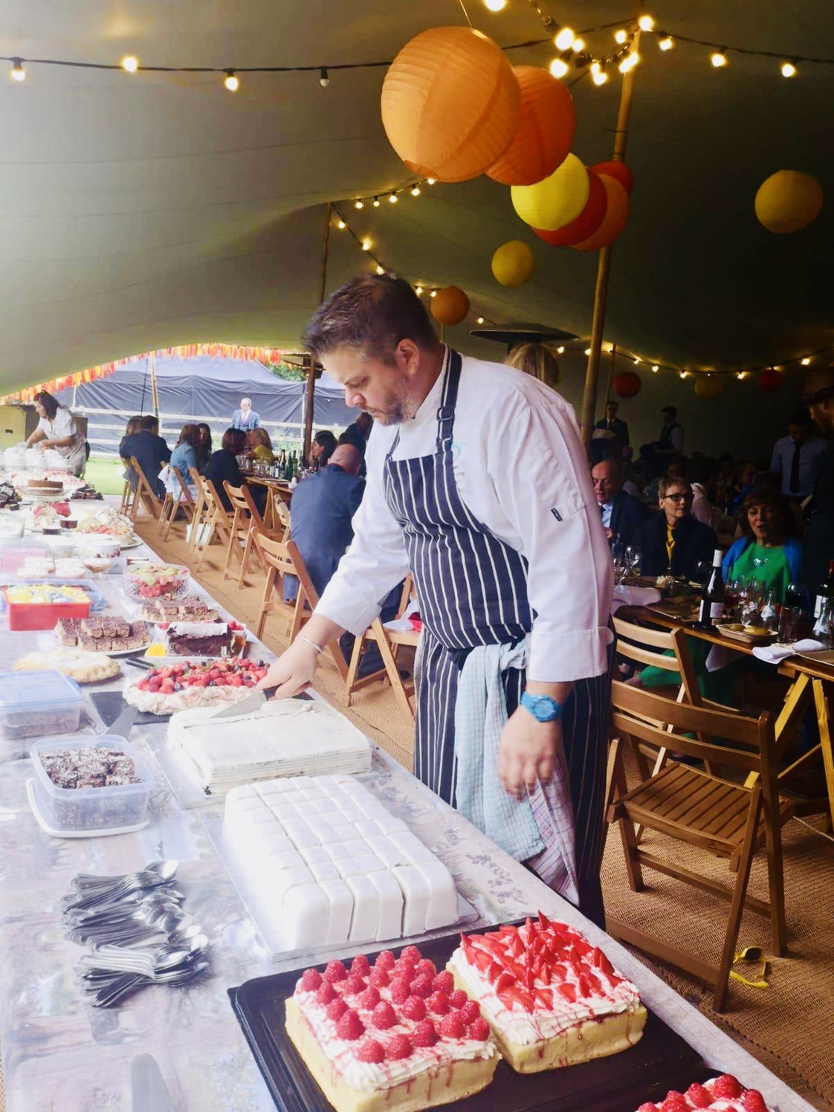 A chef serving homemade desserts at an outdoor event